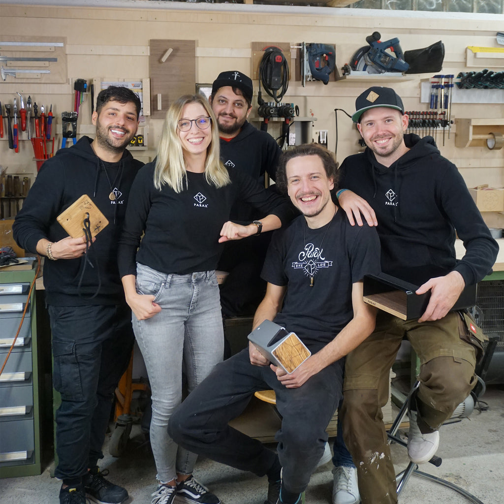 Team Parax in Parax Kleidung, mit Fahrrad Halterungen in der Hand