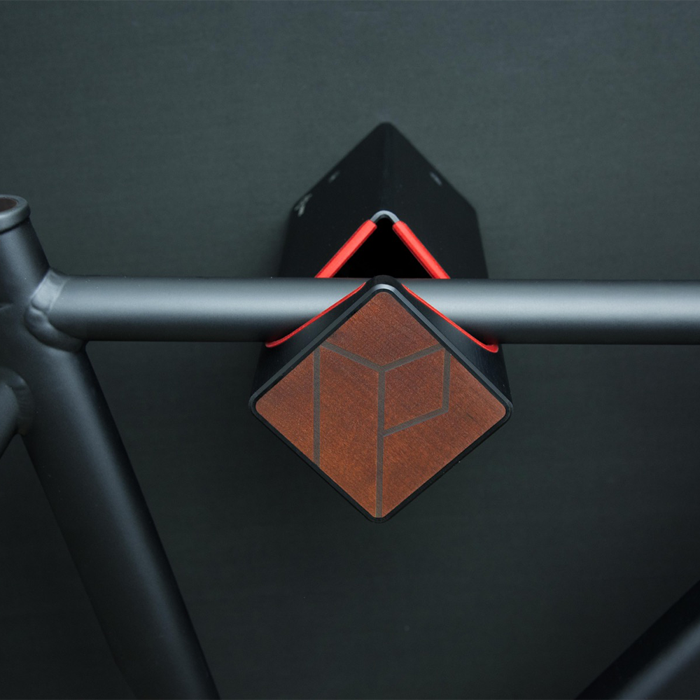 Schwarze Fahrrad Wandhalterung D-RACK mit Kebonyholzfront und schwarzem Fahrrad vor schwarzer Wand